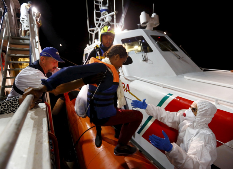 A migrant boards a coast guard vessel