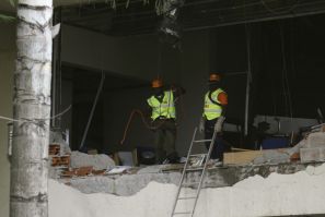 U.N. staff are seen after a bomb blast that ripped through the United Nations offices in the Nigerian capital of Abuja