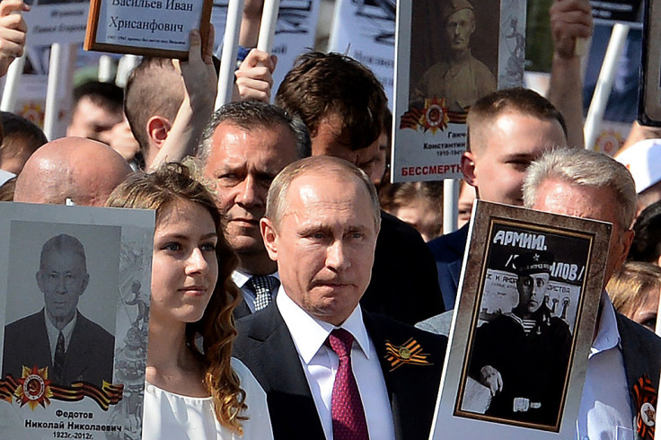 Putin holds a portrait of his fatheronthe