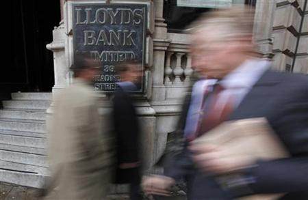 Pedestrians walk past a branch of Lloyds Bank in the City of London
