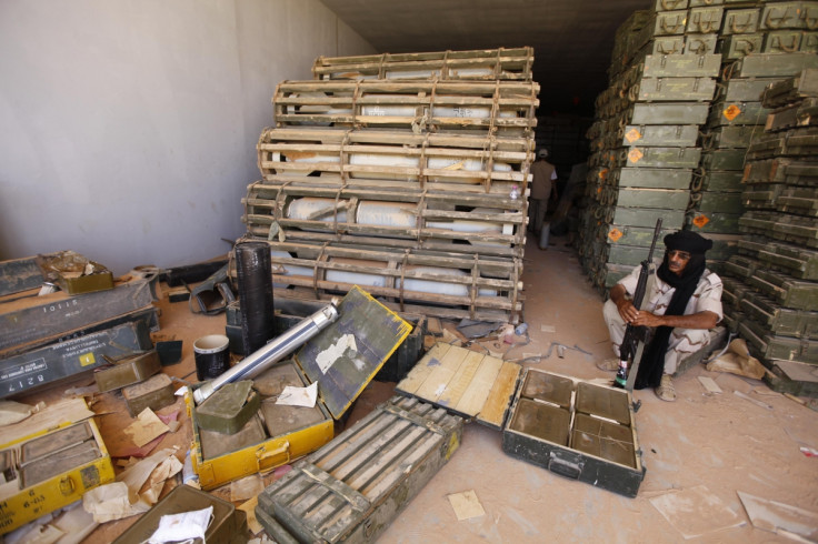 Libyan rebel fighter sits near stockpiles of ordnance inside a Gaddafi ammunition bunker