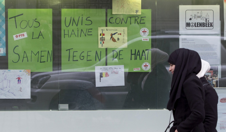 Women walk past a placard reading