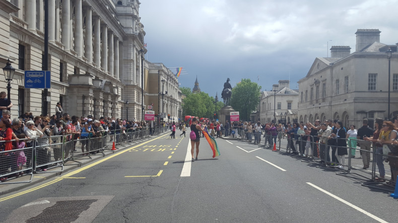 Man with rainbow flag walks down Whitehall