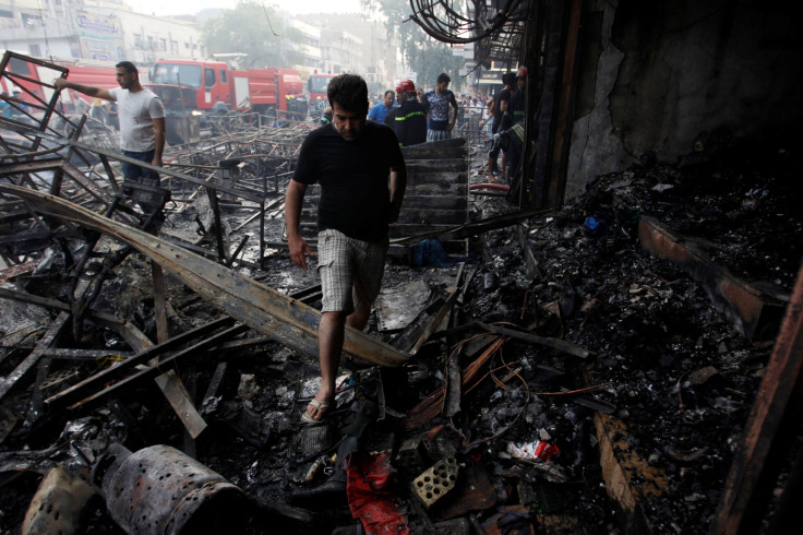 People gather at the site of a suicide car bomb in the Karrada shopping area in Baghdad