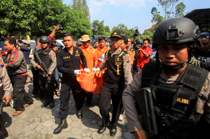 Police remove the body of a suicide bomber from the scene of an attack in Solo