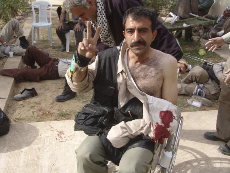 A resident gestures with a victory sign after clashes with Iraqi security forces at Camp Ashraf,
