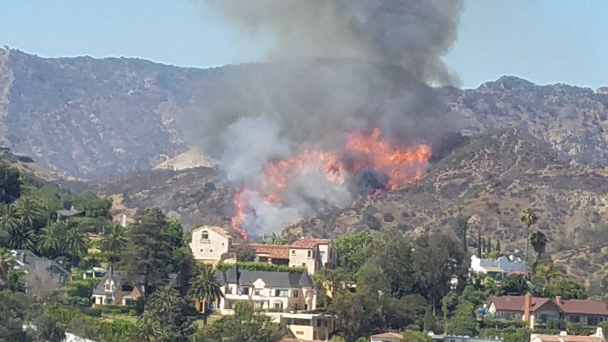 Helicopters and firefighters battled brush fire in Hollywood Hills as