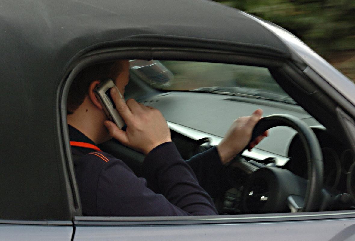 How many drivers are caught using mobile phones while travelling?