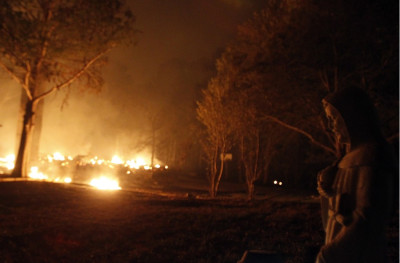 A religious figurine is illuminated by wildfires burning out of control near Bastrop A religious figurine is illuminated by wildfires burning out of control near Bastrop
