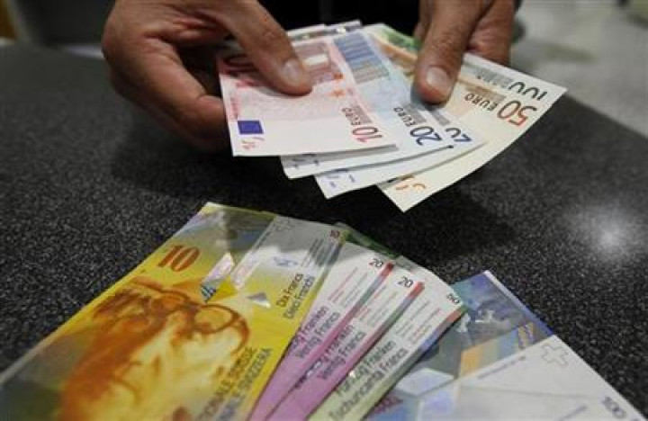 A illustration picture shows a Swiss Post clerk as he exchanges Swiss francs into Euros at a counter in a Swiss Post office in Bern A illustration picture shows a Swiss Post clerk as he exchanges Swiss francs into Euros at a counter in a Swiss Post office in Bern