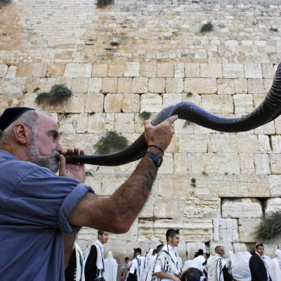 A Jewish worshipper blows a Shofar