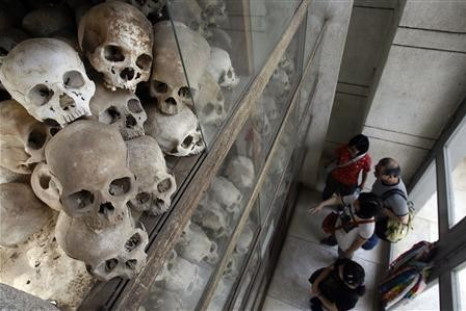 Tourists look at skulls on display at the memorial stupa filled with more than 8,000 skulls of victims of the Khmer Rouge regime at Choeung Ek
