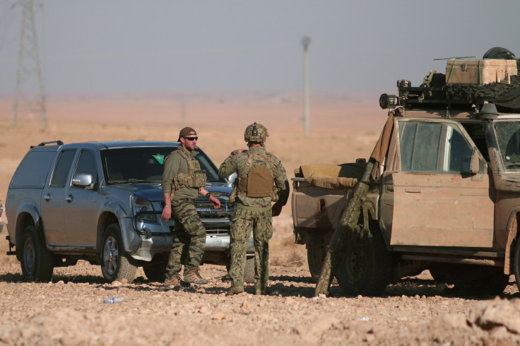 U.S. fighters stand near military vehicles U.S. fighters stand near military vehicles