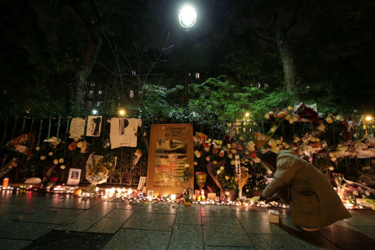 A man lights a candle at a makeshift memorial near the Bataclan concert hall