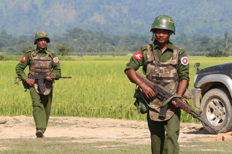 Armed Myanmar soldiers patrol a village in Maungdaw