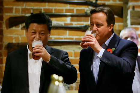 British Prime Minister David Cameron (R) drinks a pint of beer with Chinese President Xi Jinping at a pub in Princess Risborough near Chequers, northwest of London, on October 22, 2015.