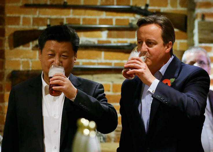 British Prime Minister David Cameron (R) drinks a pint of beer with Chinese President Xi Jinping at a pub in Princess Risborough near Chequers, northwest of London, on October 22, 2015.
