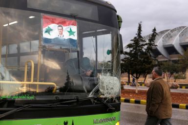 A bus driver waits to evacuate people from a rebel pocket in Aleppo