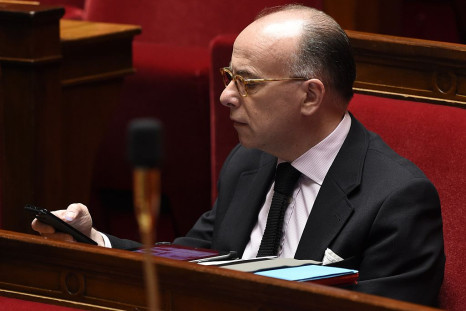 French Interior minister Bernard Cazeneuve looks at his mobile during a session of questions to the government at the National Assembly in Paris