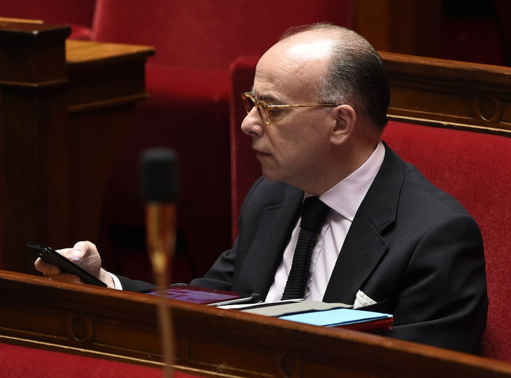 French Interior minister Bernard Cazeneuve looks at his mobile during a session of questions to the government at the National Assembly in Paris