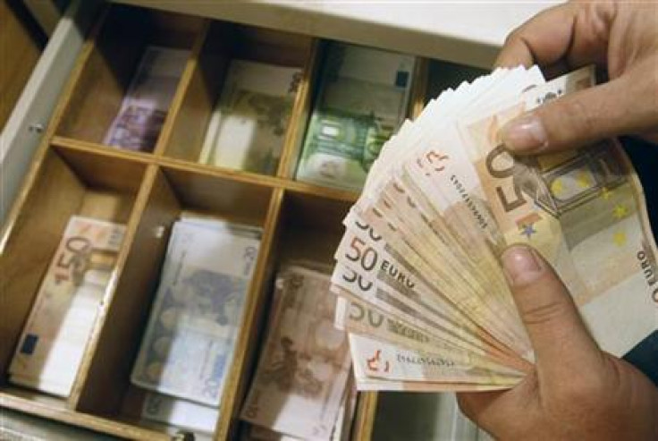 A teller counts euro banknotes inside a National Bank of Greece branch in Athens