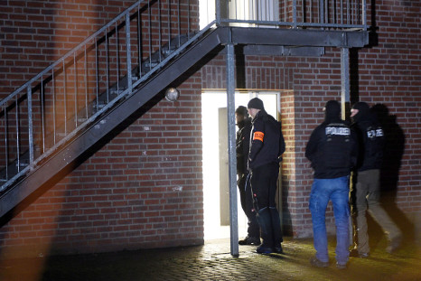 Policemen enter a home for asylum seekers in Emmerich, western Germany, on December 22, 2016.