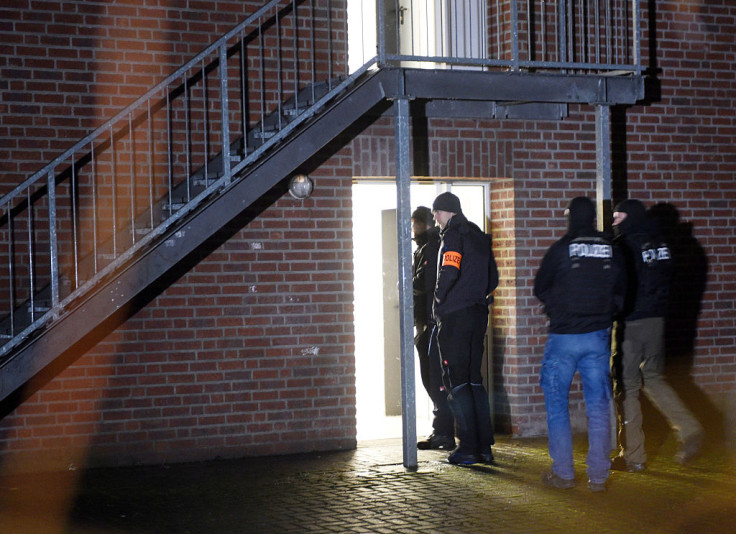 Policemen enter a home for asylum seekers in Emmerich, western Germany, on December 22, 2016.