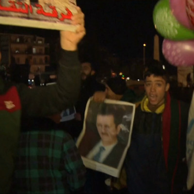 Pro-Assad Syrians celebrate in streets of Aleppo as government declares victory