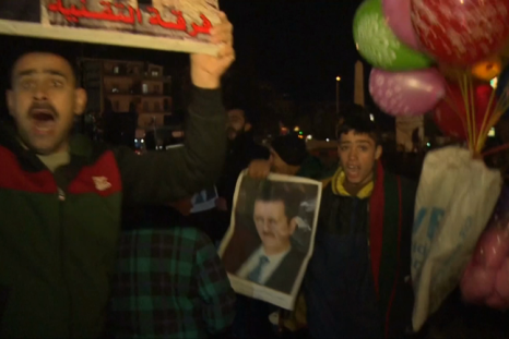 Pro-Assad Syrians celebrate in streets of Aleppo as government declares victory