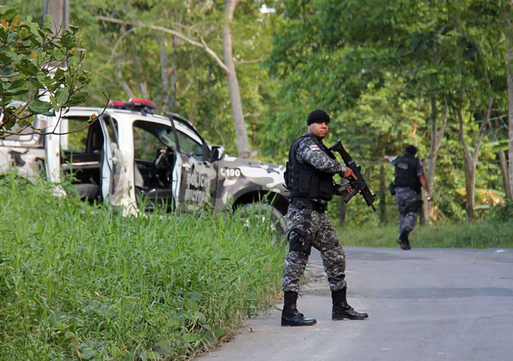 Military police officers track for fugitives of the Anisio Jobim Penitentiary Complex after a riot in the prison left at least 60 people killed and several injured,