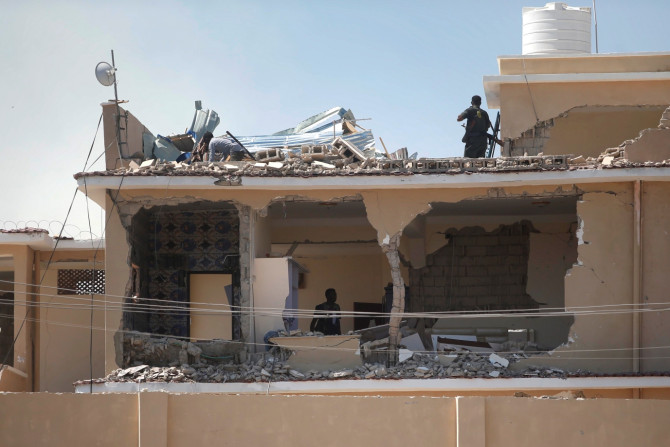 Somali policemen inspect a destroyed hotel building 