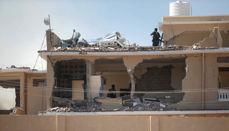 Somali policemen inspect a destroyed hotel building 