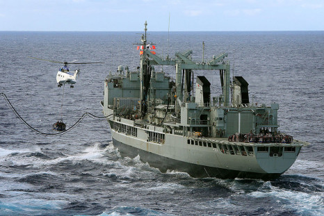 In this handout image provided by Commonwealth of Australia, Department of Defence, HMAS Success conducts a Replenishment at Sea with United States Navy Ship (USNS) Cesar Chavez, as USNS Cesar Chavez's helicopter, a Super Puma, conducts a Vertical Replen