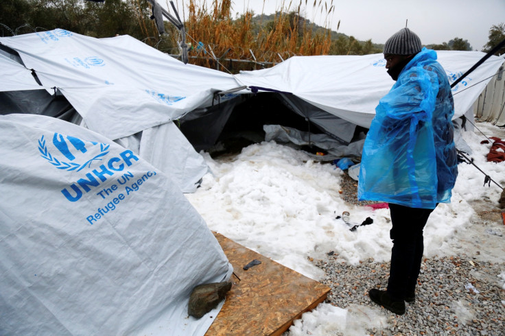 A migrant is covered with a plastic cover t