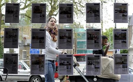 Woman stops to look in the window of an estate agent in Islington