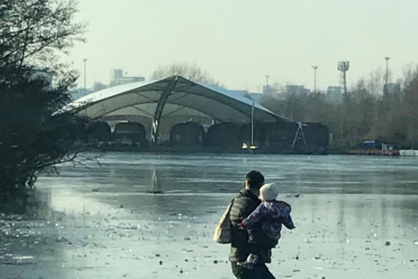 Man carries toddler across frozen lake