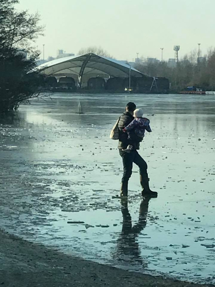Man carries toddler across frozen lake