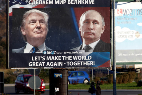 Pedestrians cross the street behind a billboard showing a pictures of US president-elect Donald Trump and Russian President Vladimir Putin in Danilovgrad, Montenegro, 