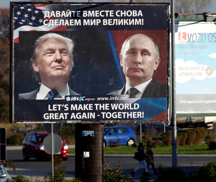 Pedestrians cross the street behind a billboard showing a pictures of US president-elect Donald Trump and Russian President Vladimir Putin in Danilovgrad, Montenegro, 
