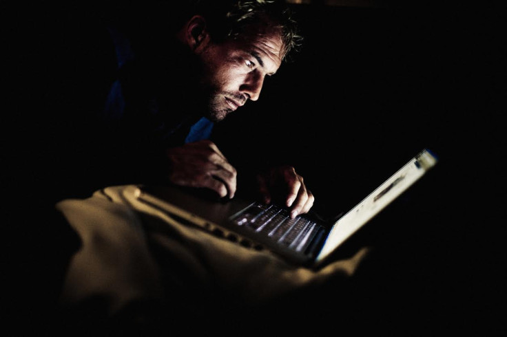 Man looking at laptop in the dark