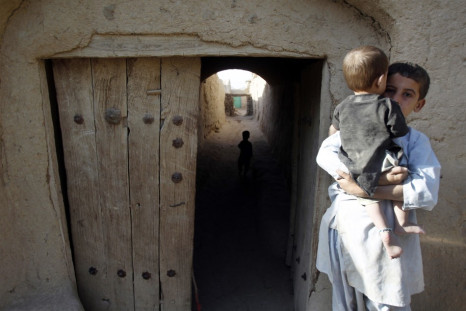 An Afghan boy holds a baby in the village of Small Loi Kola