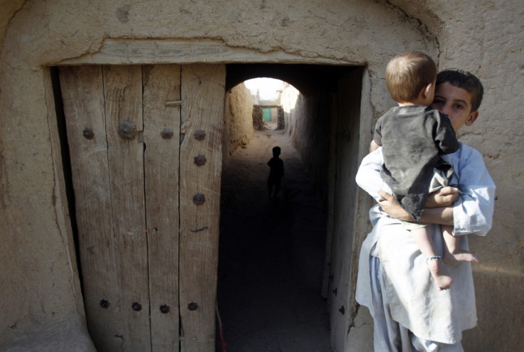 An Afghan boy holds a baby in the village of Small Loi Kola