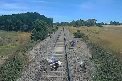 Biker forced to leap to safety after near-miss with train