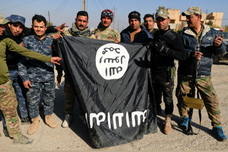 Iraqi security forces members pose with a seized Islamic State flag after driving out its miitants from Mosul's airport south west Mosul
