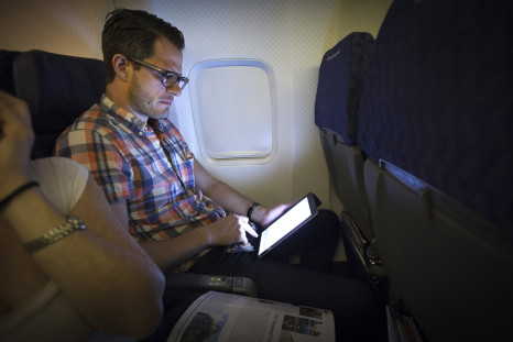 Man using tablet on an airplane
