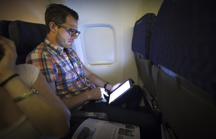 Man using tablet on an airplane