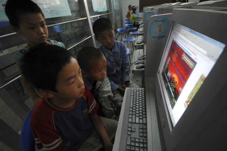 Chinese children play online games at internet cafe.