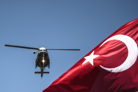 Turkish military helicopter flies behind flag