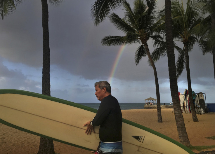 Surfers walks along the beach in Hawaii