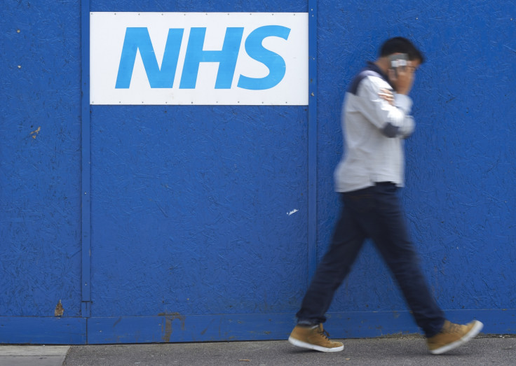 Man walking past NHS sign